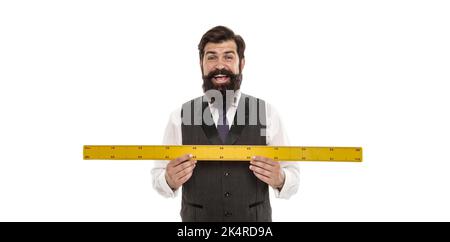 Professeur de mathématiques prenant des mesures. C'est trop grand. Homme heureux mesure la longueur. Homme barbu avec règle isolée sur blanc. Professeur de géométrie gaie Banque D'Images