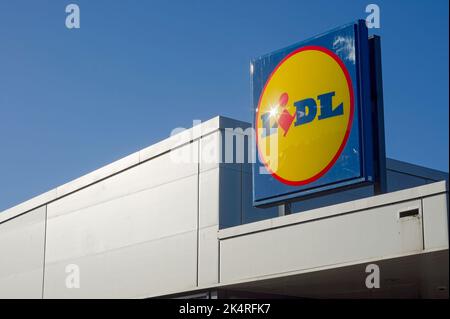 Gros plan de l'affiche du magasin Lidl avec reflet du soleil sur un fond bleu ciel Banque D'Images