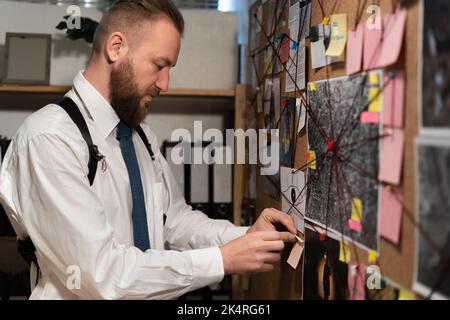 détective de recherche. Vue rapprochée d'un détective avec un tableau des preuves dans le bureau Banque D'Images