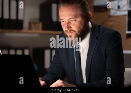 Détective traitant des preuves au bureau, travaillant sur ordinateur Banque D'Images