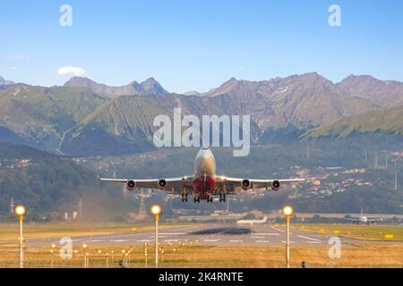 L'aéroport de montagne et un grand avion de ligne à quatre moteurs s'envol sur fond de vues pittoresques sur les crêtes rocheuses Banque D'Images