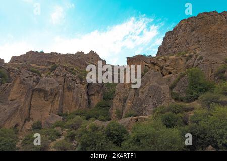 Montagnes rocheuses et boisées près du monastère de Geghard, par une journée ensoleillée et nuageux, au coucher du soleil, pendant l'heure d'or Banque D'Images