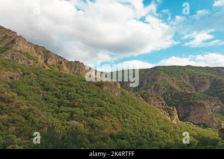 Montagnes rocheuses et boisées près du monastère de Geghard, par une journée ensoleillée et nuageux, au coucher du soleil, pendant l'heure d'or Banque D'Images