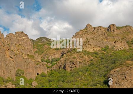 Montagnes rocheuses et boisées près du monastère de Geghard, par une journée ensoleillée et nuageux, au coucher du soleil, pendant l'heure d'or Banque D'Images