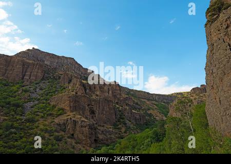 Montagnes rocheuses et boisées près du monastère de Geghard, par une journée ensoleillée et nuageux, au coucher du soleil, pendant l'heure d'or Banque D'Images