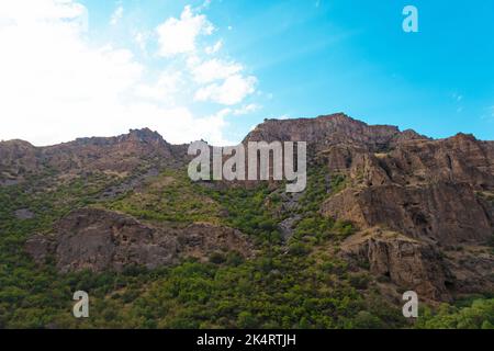 Montagnes rocheuses et boisées près du monastère de Geghard, par une journée ensoleillée et nuageux, au coucher du soleil, pendant l'heure d'or Banque D'Images