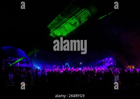 Des lumières laser colorées brillent et se déplacent sur la foule dansante pendant la fête du DJ Banque D'Images