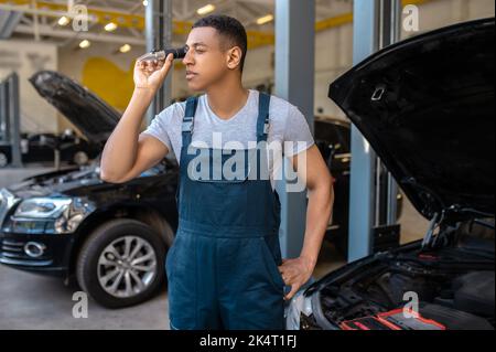 Un mécanicien professionnel inspecte une nouvelle pièce d'automobile Banque D'Images