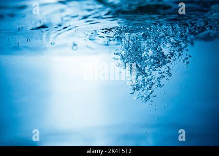 Arrière-plan abstrait créé par des bulles d'air dans l'eau sous lumière bleue. Banque D'Images