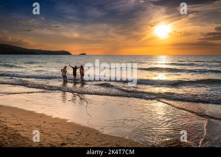 Vacanciers profitant d'un coucher de soleil spectaculaire sur la baie de Fistral à Newquay en Cornouailles au Royaume-Uni en Europe. Banque D'Images