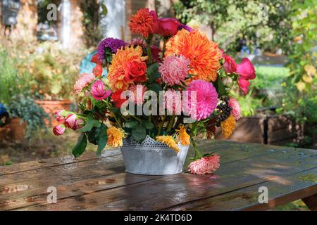 Fleurs: roses, asters, dahilia dans le jardin des pommes sur une table en bois. Design floristique. Jour ensoleillé Banque D'Images