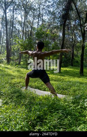 homme vu de près, sans chemise s'étire sur le tapis de yoga, exercice, amérique latine Banque D'Images