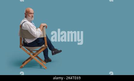 Réalisateur professionnel confiant assis sur la chaise du réalisateur et regardant la caméra : école de théâtre, production vidéo et concept de l'industrie cinématographique, blana Banque D'Images