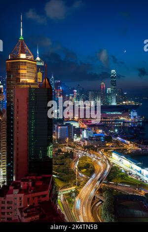 Les bâtiments commerciaux en hauteur de Causeway Bay, WAN Chai et Central, sur l'île de Hong Kong, au crépuscule avec une nouvelle lune et des sentiers légers des voitures, 2011 Banque D'Images