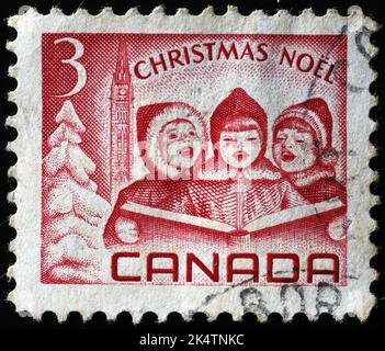 Les enfants chantent pour Noël sur l'ancien timbre canadien Banque D'Images