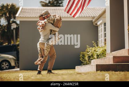 Joyeux retour militaire. Soldat joyeux embrassant son mari après son retour de l'armée. La militaire américaine se réunirait avec son husban Banque D'Images