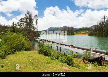 Montagnes imposantes, rivière avec petite île visible, ciel bleu et blanc, reflet visible dans l'eau, cadeau de la nature de verdure partout Banque D'Images