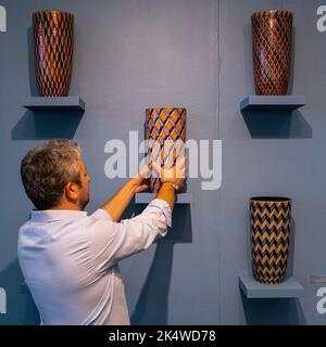 Londres, Royaume-Uni. 4 octobre 2022. Un membre du personnel apporte des ajustements aux « vases romains et byzantins », 2020-2022, par Bottega Vignoli sur le stand de MADEINBRITALY » à la Foire de décoration de Evolution London, Battersea Park. 140 exposants présentent des antiquités, du design et de l'art spécifiquement pour l'acheteur de design d'intérieur dans un salon qui s'étend jusqu'au 9 octobre 2022. Credit: Stephen Chung / Alamy Live News Banque D'Images