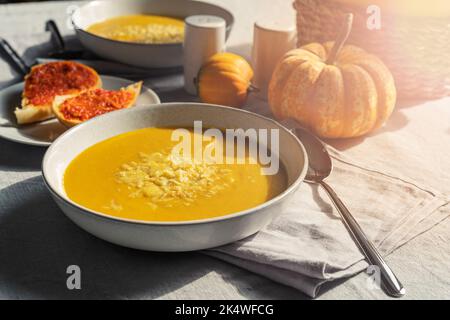 Bol de soupe crémeuse à la citrouille maison avec fromage et pain au poivre rouge Banque D'Images