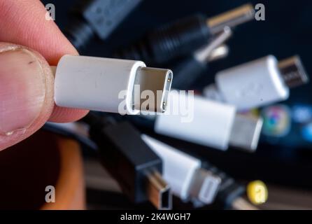 Schwerin, Allemagne. 04th octobre 2022. Un câble de chargement avec connecteur USB-C est maintenu à côté d'un faisceau de différents câbles de connexion. Il y aura des câbles de charge uniformes dans l'UE à partir de 2024. Le Parlement européen a approuvé la norme de charge uniforme USB-C pour les smartphones et de nombreux autres appareils. Credit: Jens Büttner/dpa/Alay Live News Banque D'Images