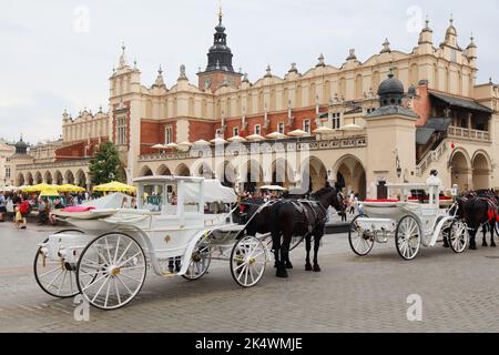 CRACOVIE, POLOGNE - 3 JUILLET 2021 : les gens visitent la place Rynek lors d'un jour de pluie à Cracovie, en Pologne. Le centre historique de Cracovie est un si classé au patrimoine mondial de l'UNESCO Banque D'Images