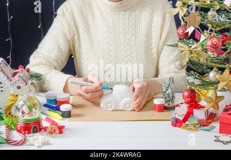 Instructions étape par étape pour la photo d'un décor de Noël - une fille peint une machine à plâtre, étape 1 - préparation Banque D'Images