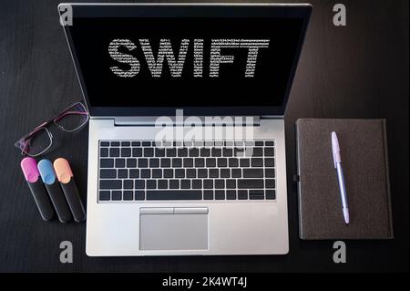 Vue de dessus de l'ordinateur portable avec texte Swift. Banque D'Images