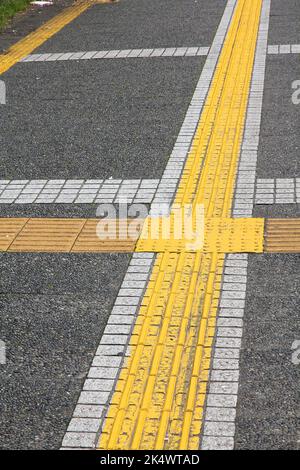 Pavage tactile sur un trottoir à Nagoya, Japon. Infrastructure piétonne pour les personnes malvoyantes. Banque D'Images