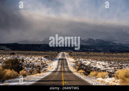 Des nuages de neige se forment au-dessus de l'Utah 211 en route vers le quartier des aiguilles de Canyonlands Banque D'Images