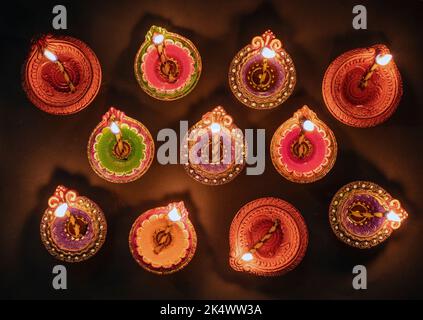 Diwali, festival hindou des lumières de Deepavali. Voyant huile diya allumé sur fond noir, vue du dessus. Banque D'Images