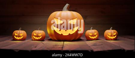Citrouilles d'Halloween sur table en bois. Sourire sculpté et yeux effrayants illuminés dans un arrière-plan sombre. Banque D'Images
