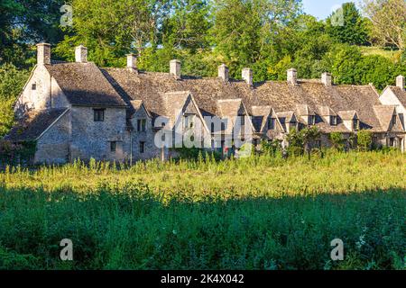 Feu tôt le matin sur Arlington Row dans le village de Cotswold à Bibury, Gloucestershire, Angleterre Royaume-Uni Banque D'Images