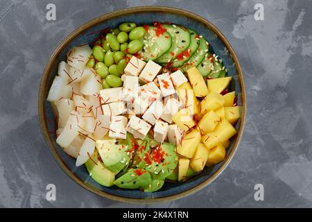 Vue de dessus sur la salade de poke avec crabe et légumes verts dans les bols sur fond gris. Copier l'espace. Banque D'Images