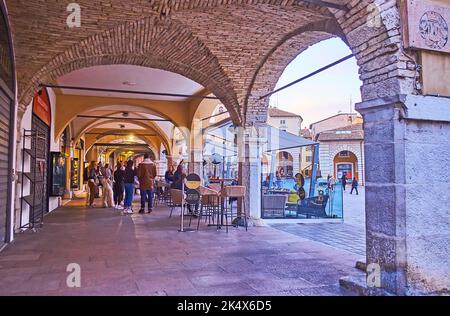 DESENZANO DEL GARDA, ITALIE - 10 AVRIL 2022 : l'arcade médiévale avec de petits magasins et restaurants, sur la Piazza Giuseppe Malvezzi, sur 10 avril à Desenza Banque D'Images