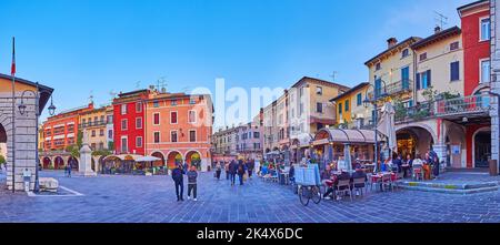 DESENZANO DEL GARDA, ITALIE - 10 AVRIL 2022: Panorama du crépuscule Piazza Giuseppe Malvezzi avec de confortables restaurants et bars extérieurs, sur 10 avril in Banque D'Images