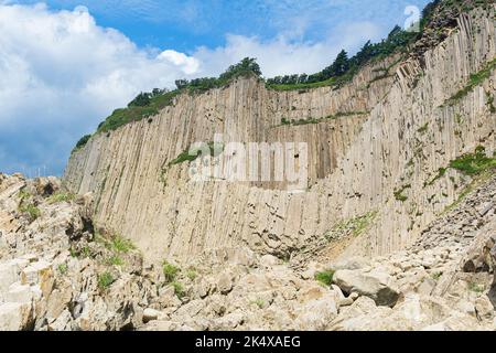 Haute falaise côtière formée par des colonnes de pierres de lave solidifiées, cap Stolbchaty sur l'île de Kunashir Banque D'Images