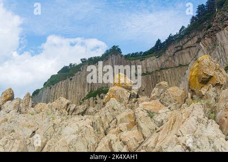 Haute falaise côtière formée par des colonnes de pierres de lave solidifiées, cap Stolbchaty sur l'île de Kunashir Banque D'Images