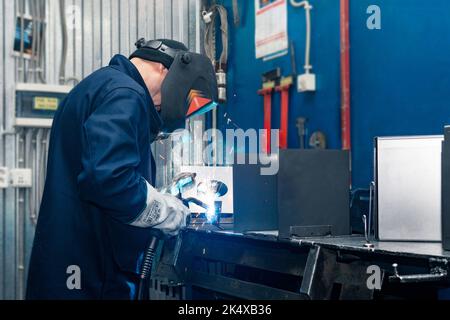 Perm, Russie - 21 septembre 2022 : soudeur au travail, soudeur de pièces métalliques en atelier Banque D'Images