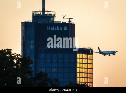 04 octobre 2022, Hessen, Francfort-sur-le-main : les visiteurs se tiennent sur la plateforme d'accueil de la Helaba au coucher du soleil (en haut à gauche), tandis qu'à droite derrière le gratte-ciel, un avion Lufthansa Cargo se trouve à l'approche de l'aéroport de Francfort. Photo: Frank Rumpenhorst/dpa Banque D'Images