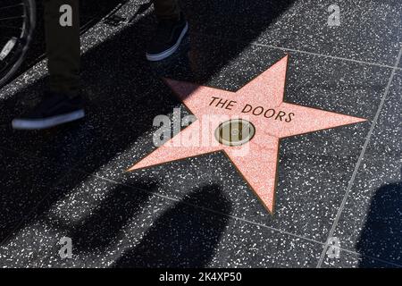 La célèbre étoile des « portes » incrustée dans le sol en terrazzo du Hollywood Boulevard Walk of Fame entourée d'ombres de touristes. Banque D'Images