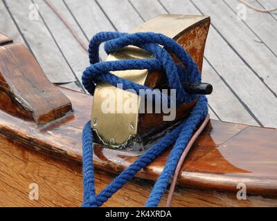 Bollard d'amarrage sur le pont d'un navire en bois avec une corde bleue. Banque D'Images