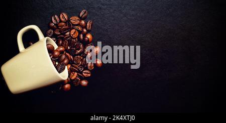Tasse renversée et grains de café brûlés éparpillés sur la table. Grunge l'image. Modèle de nourriture et de boisson avec espace de copie Banque D'Images