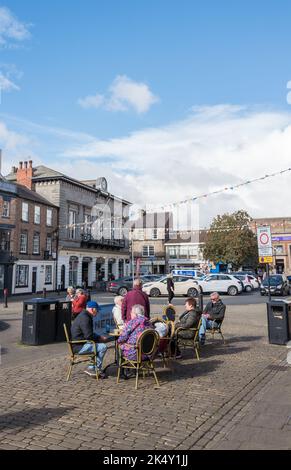 Les clients et les amateurs de shopping se détendent en fin d'après-midi sous le soleil d'automne à la place du marché de Knaresborough, à Knaresborough, dans le Yorkshire, en Angleterre, au Royaume-Uni. Banque D'Images