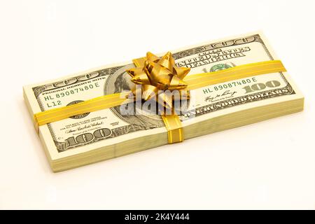 Lot de dollars avec un noeud cadeau. Pile de dollars. Billets EN dollars AMÉRICAINS. Une pile de billets américains de cent dollars. Concept de l'activité bancaire Banque D'Images