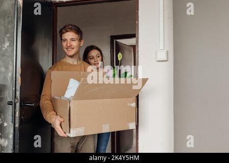 Vertical souriant, curieux, communicatif étudiants débutants prenant des boîtes de carton avec des choses. Vie universitaire, début de l'éducation Banque D'Images