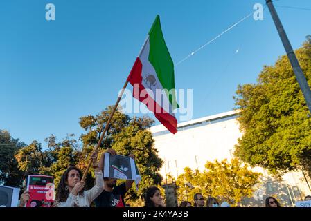 Barcelone, Espagne. 04th octobre 2022. Un manifestant fait pression sur le drapeau iranien au cours de la manifestation. Des manifestations similaires ont eu lieu dans des villes du monde entier pour demander justice pour le meurtre de Mahsa Amini, une jeune femme qui a été détenue à Téhéran par la police morale iranienne pour ne pas avoir correctement porté le hijab en public. Crédit : SOPA Images Limited/Alamy Live News Banque D'Images