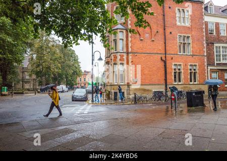 Les touristes et les visiteurs se protègent de la pluie en utilisant des parasols et des manteaux de pluie sur les rues humides près de la cathédrale de York. Banque D'Images