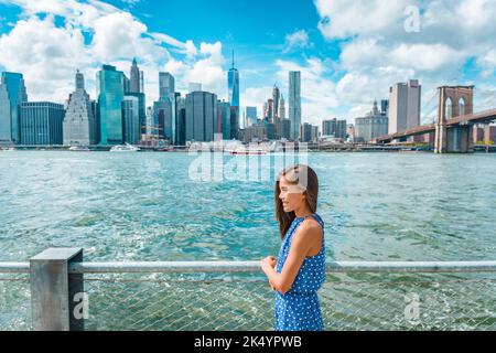 New York vue de Manhattan depuis le front de mer de Brooklyn - une femme regarde la vue. Les Américains marchent en profitant de la vue sur Manhattan Banque D'Images