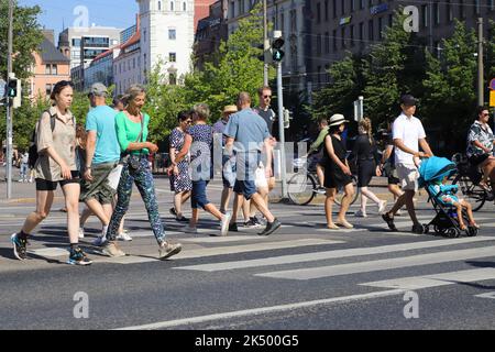 Helsinki, Finlande - 20 août 2022 : gens à un passage en croix près de la place Hakaniemi. Banque D'Images