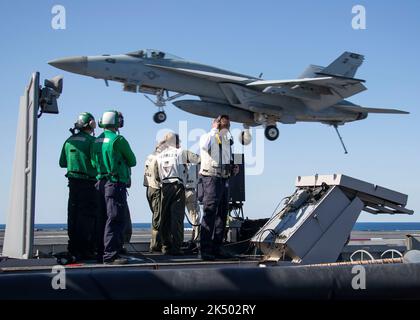 Les marins DE L'OCÉAN ATLANTIQUE (11 avril 2022) affectés au porte-avions USS Gerald R. Ford (CVN 78) et à l'escadre aérienne Carrier (CVW) 8 observent le stand sur la plate-forme de l'officier de sécurité à l'atterrissage tandis qu'un trowler E/A-18G attaché à l'escadron 142 « loups gris » d'attaque électronique (VAQ) approche du pont de vol, 11 avril 2022. Gerald R. Ford est en cours dans l'océan Atlantique en menant des qualifications de transporteur et l'intégration du groupe de grève dans le cadre de la phase de base sur mesure shipÕs avant le déploiement opérationnel. (É.-U. Photo de la marine par le spécialiste des communications de masse 3rd classe Jackson Adkins) Banque D'Images